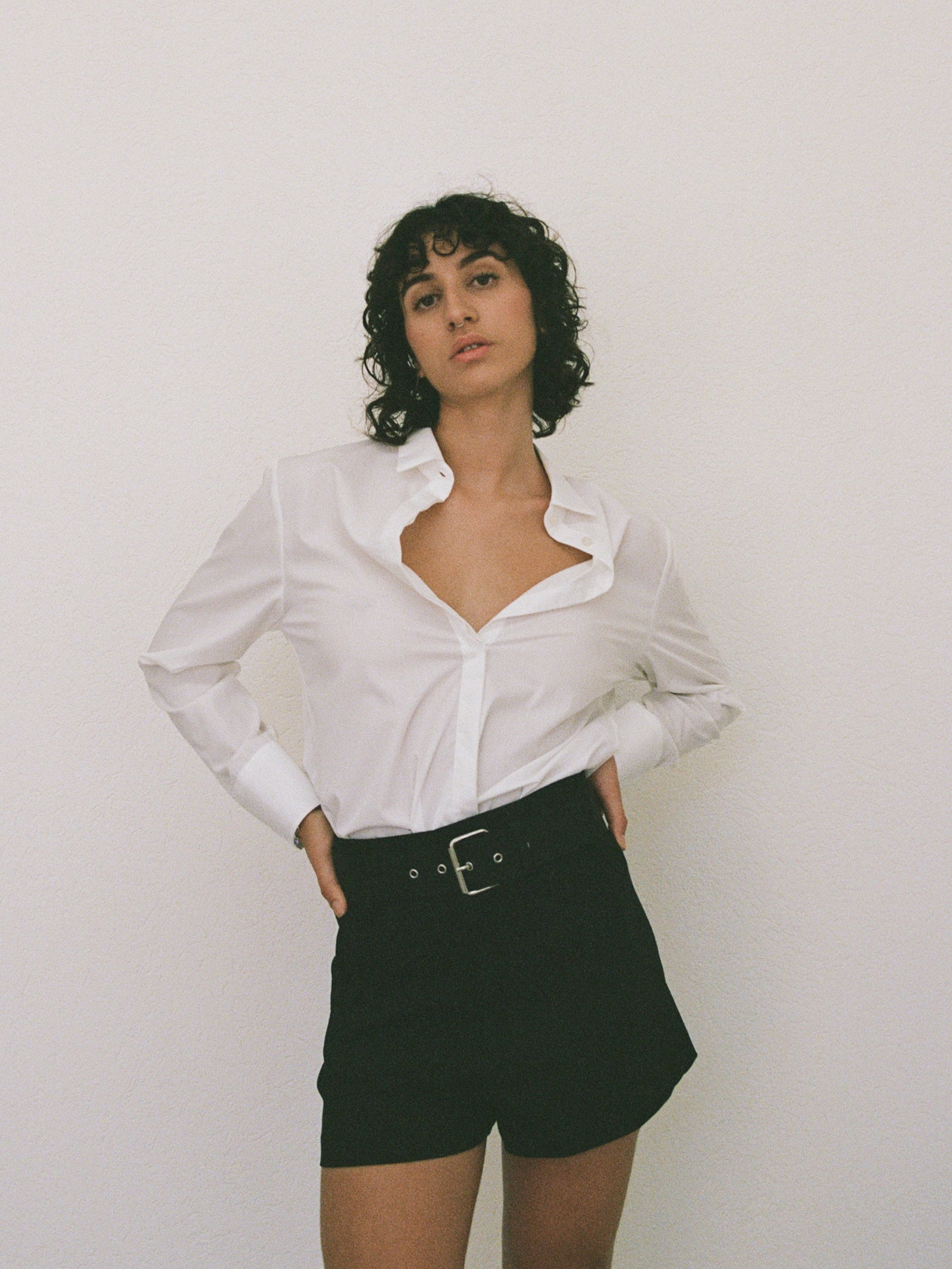 yvy leather wide buckle belt 5 in black with silver hardware on a model wearing it with the white shirt and black shorts