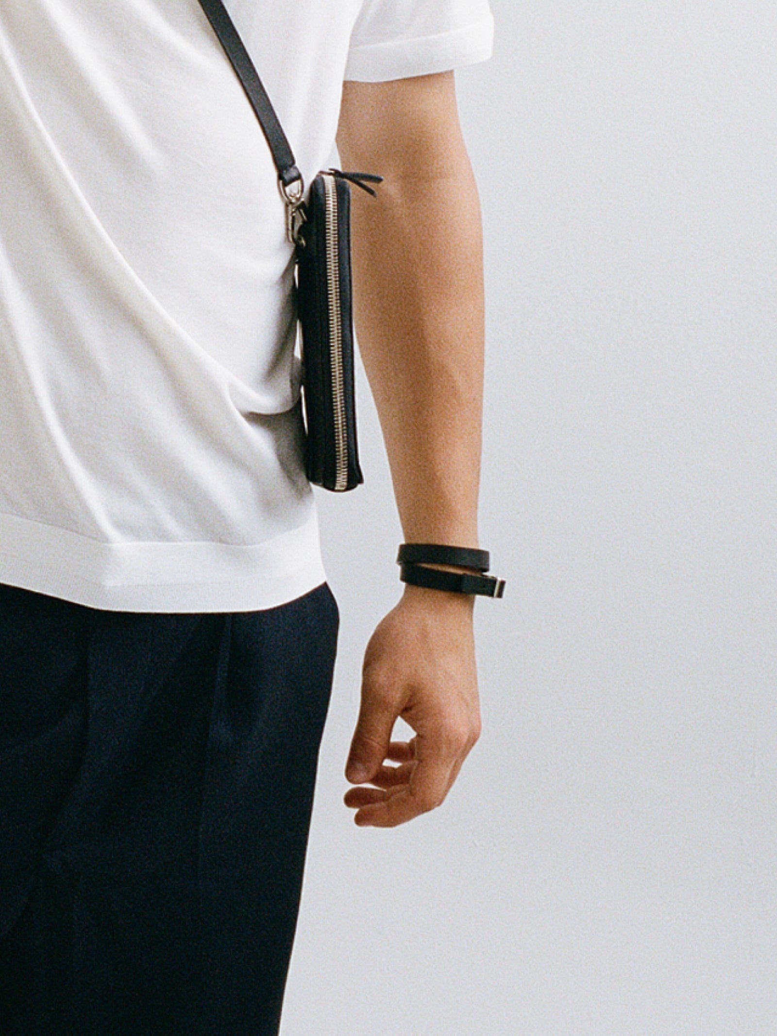 male arm showcasing black leather yvy choker wrapped twice around the wrist and worn as a bracelet