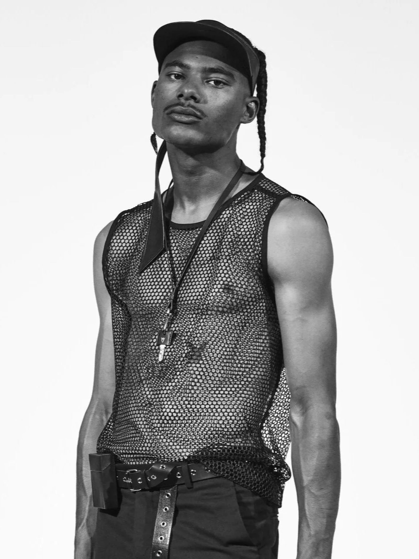 man wearing yvy leather scarf visor with net vest and black pants