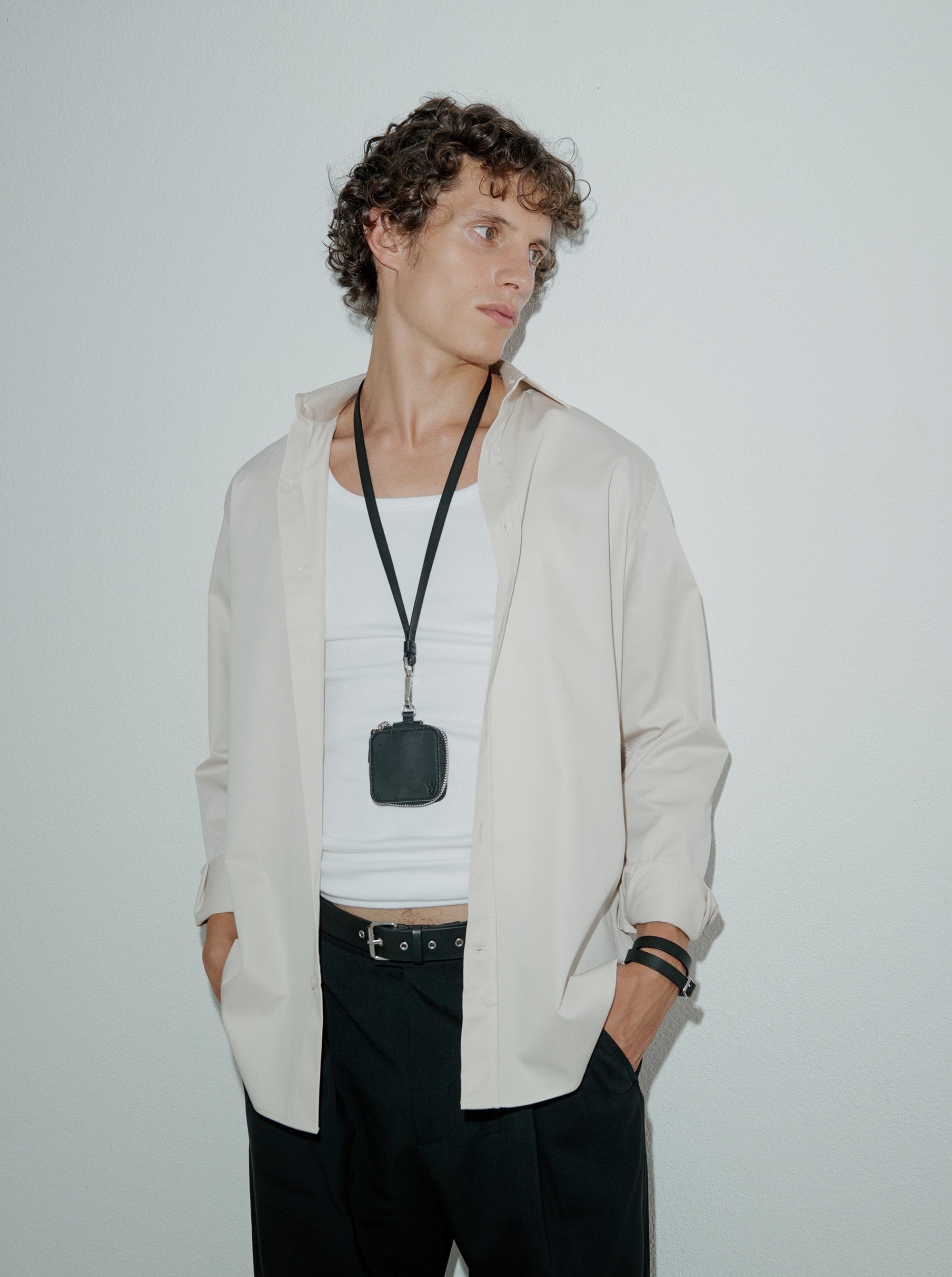 man wearing yvy long leather minimalist keychain over neck with mini box