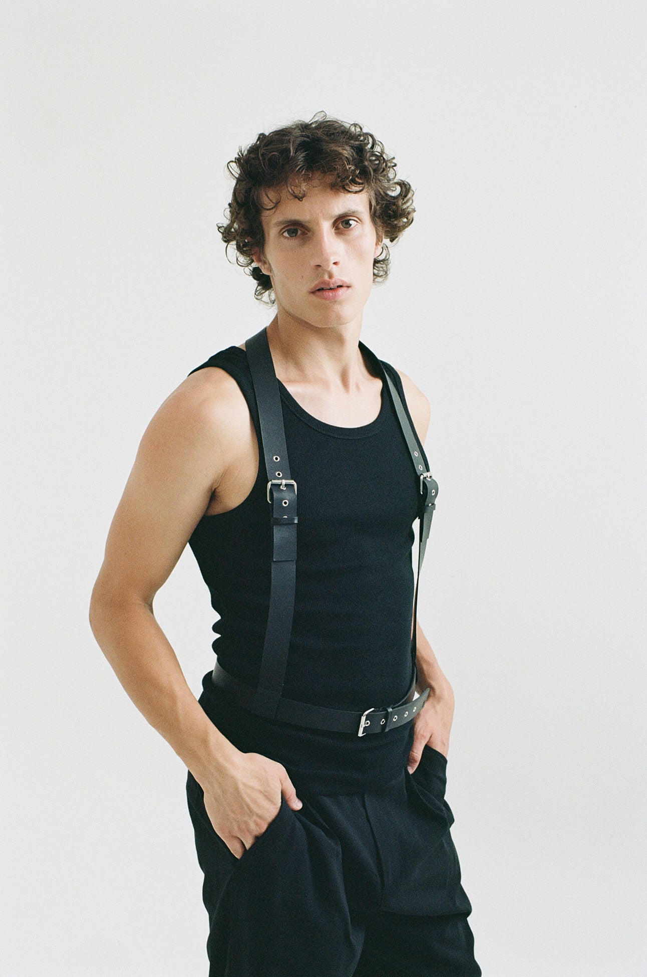 male model wearing yvy leather men's uni harness in black with black tank top and pants