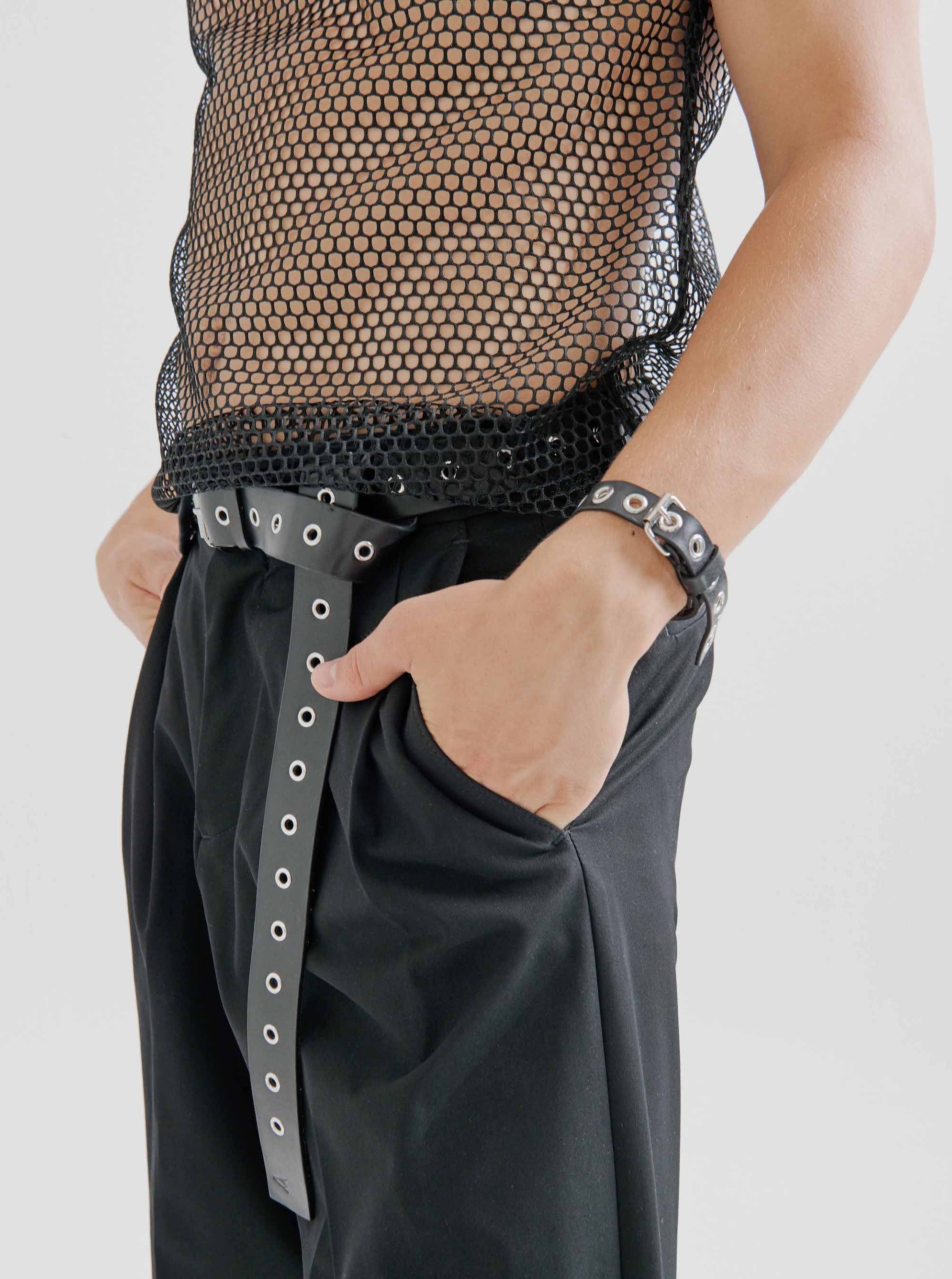 close up of man wearing yvy leather eyelet bracelet with eyelet belt and net top