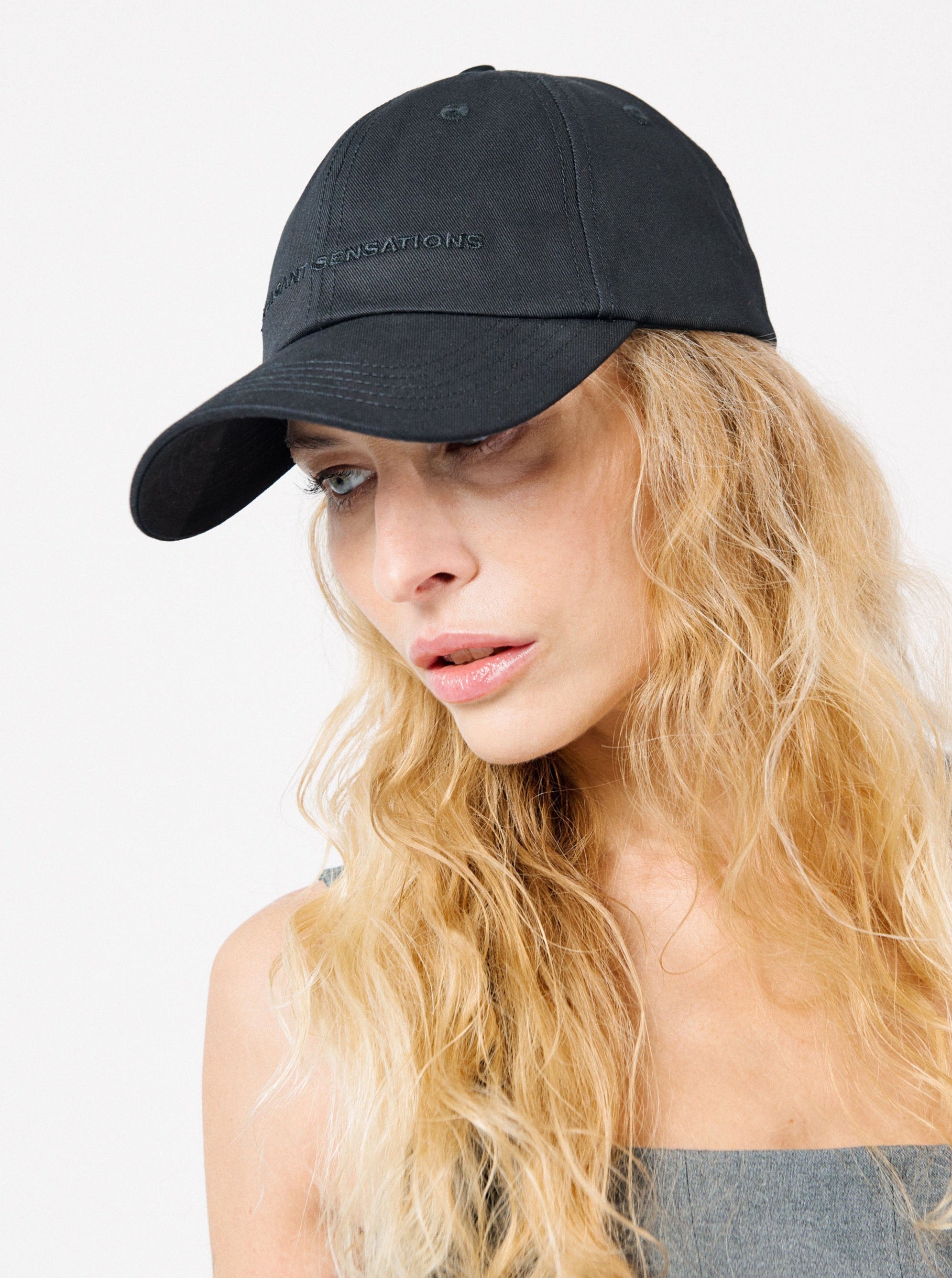 a woman wearing classic six-panel yvy cap with adjustable back, black metal buckle and black embroidery