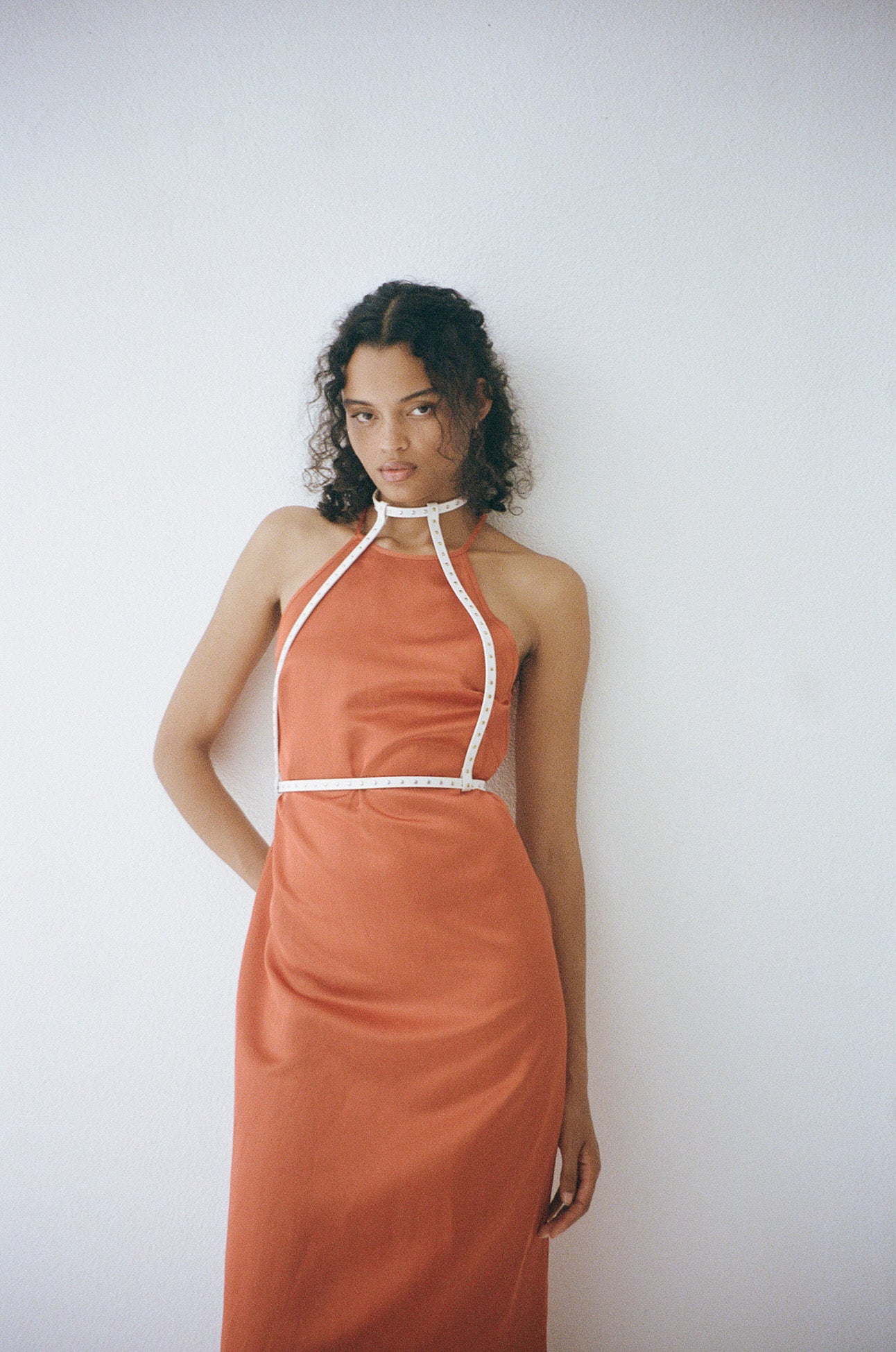female model wearing yvy leather minimalist harness two tone in white over an orange satin maxi dress