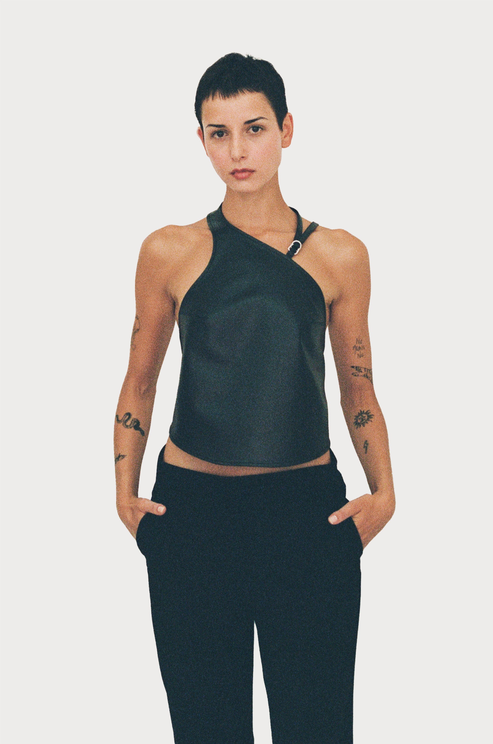 a female model wearing black yvy leather halter neck top and black pants