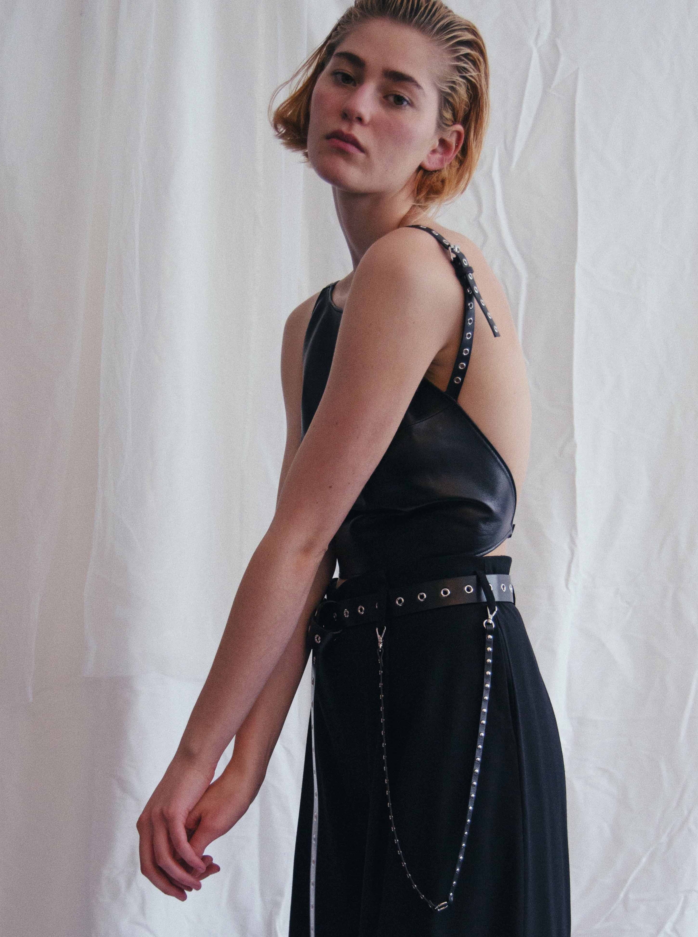 woman wearing yvy black leather neck strap with silver rivets on pants