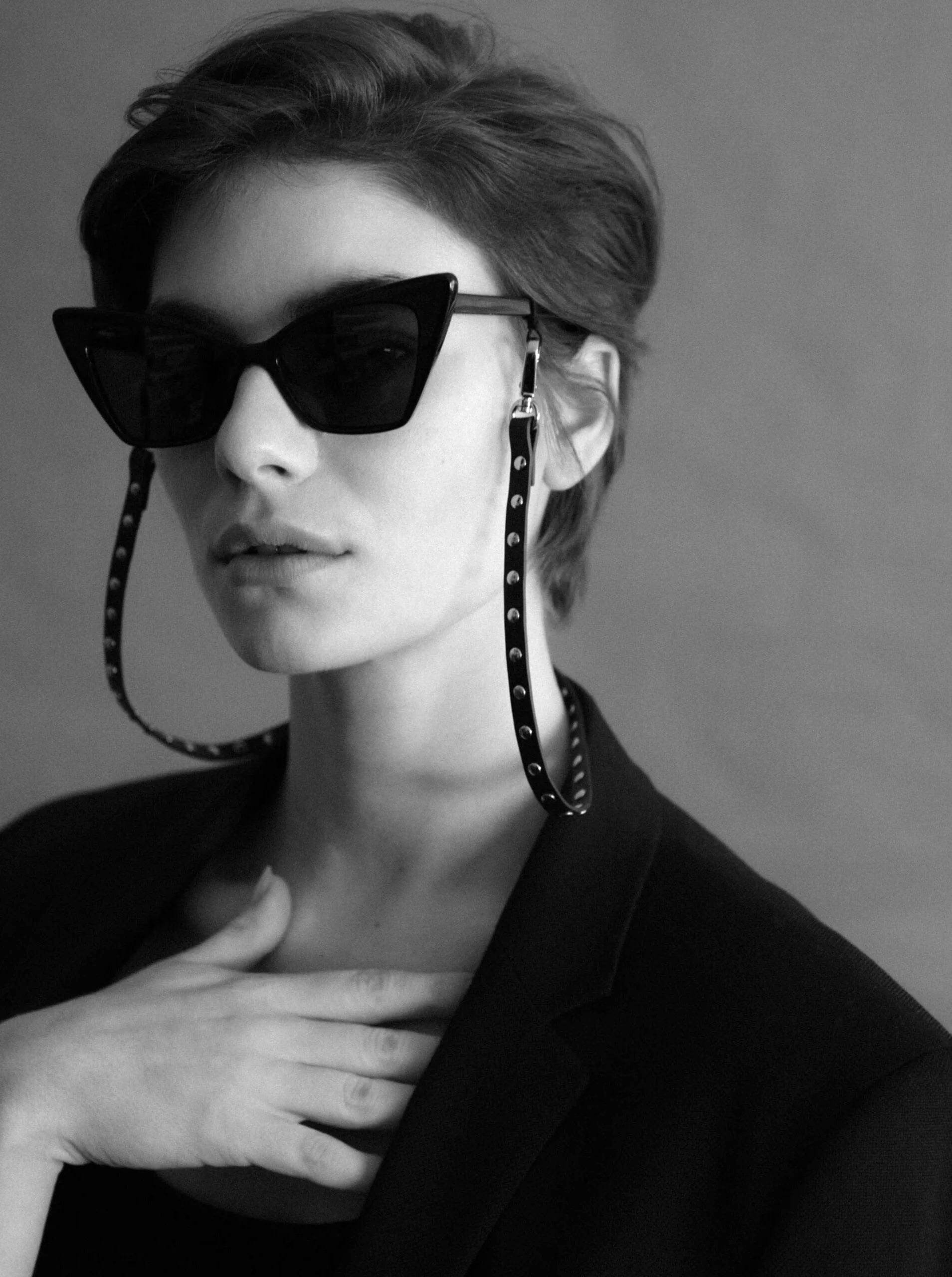 female model wearing sunglasses attached to the studded leather yvy sunglasses strap