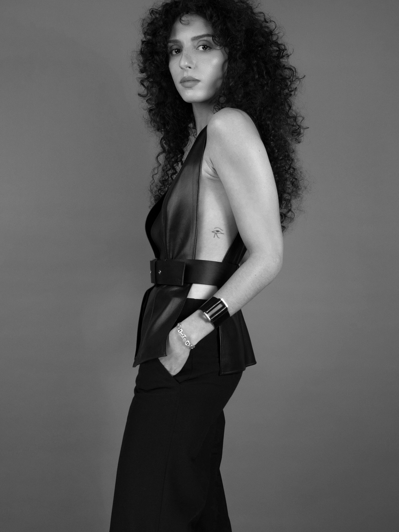 a woman wearing yvy black leather open vest with buckle and eileen bracelet with silver hardware