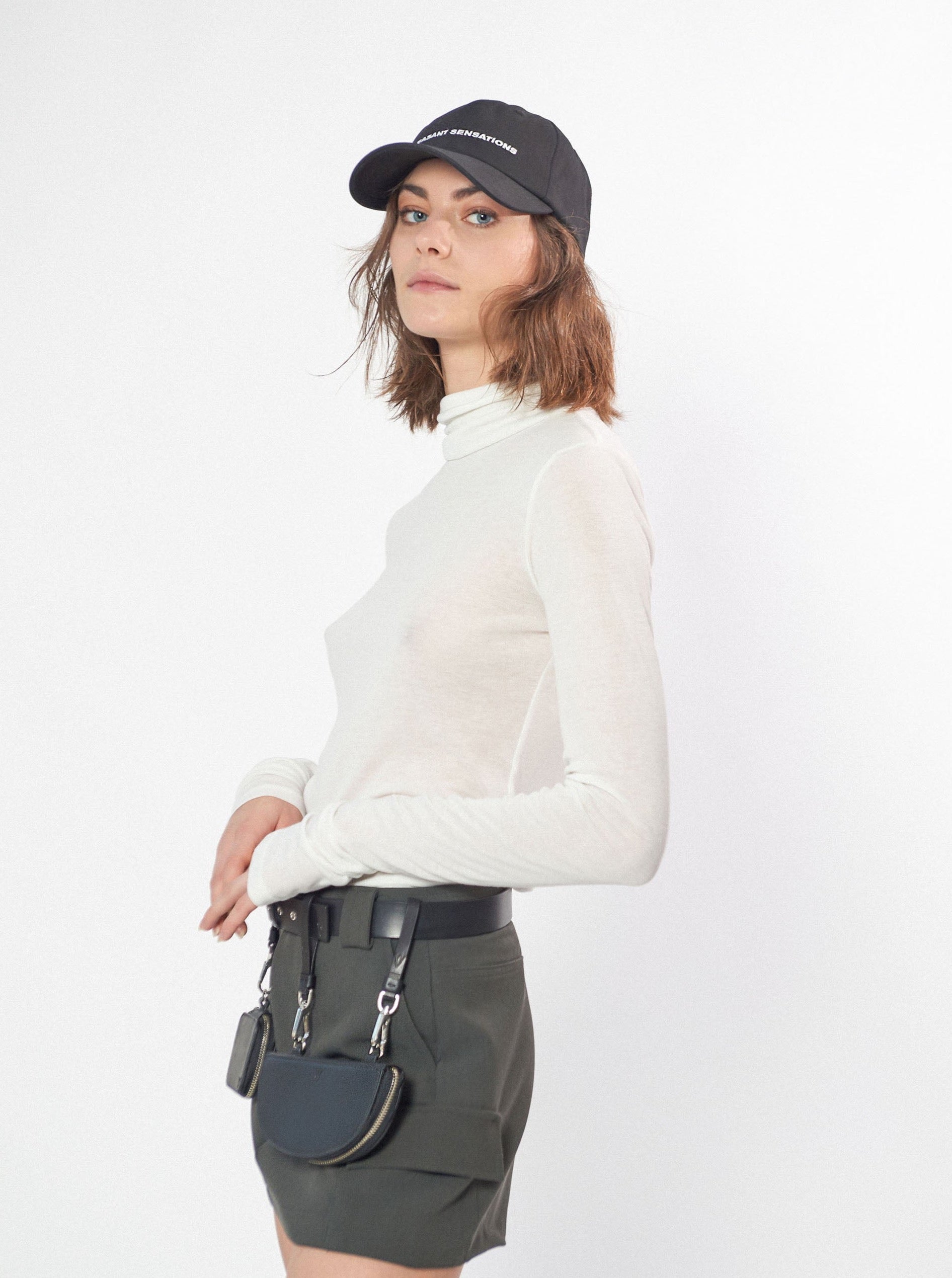 a woman wearing classic six-panel yvy cap with adjustable back, black metal buckle and white embroidery