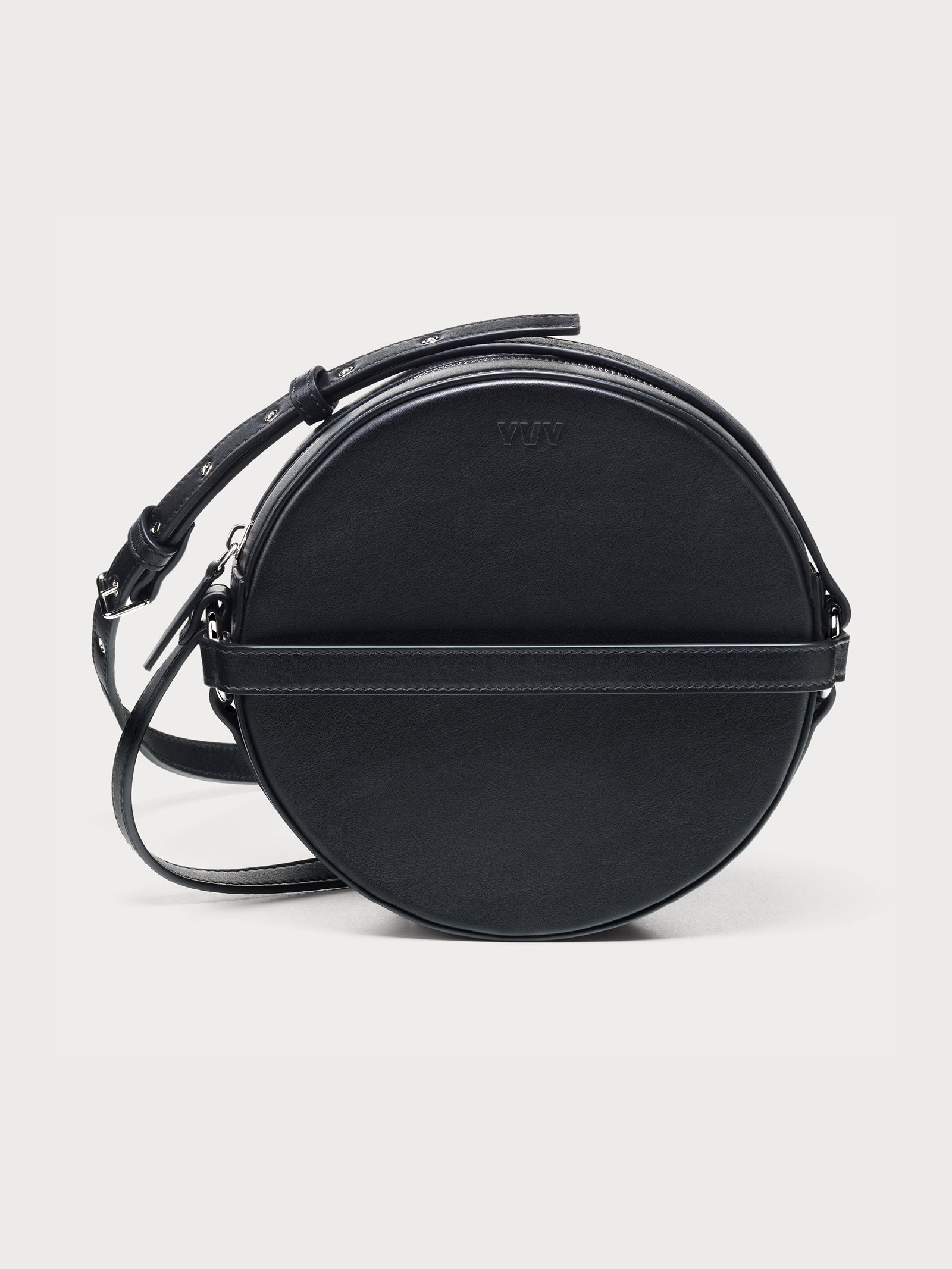 Elegant black round crossbody yvy bag with an adjustable strap with silver hardware, horizontal leather band detail, and a smooth leather surface. 