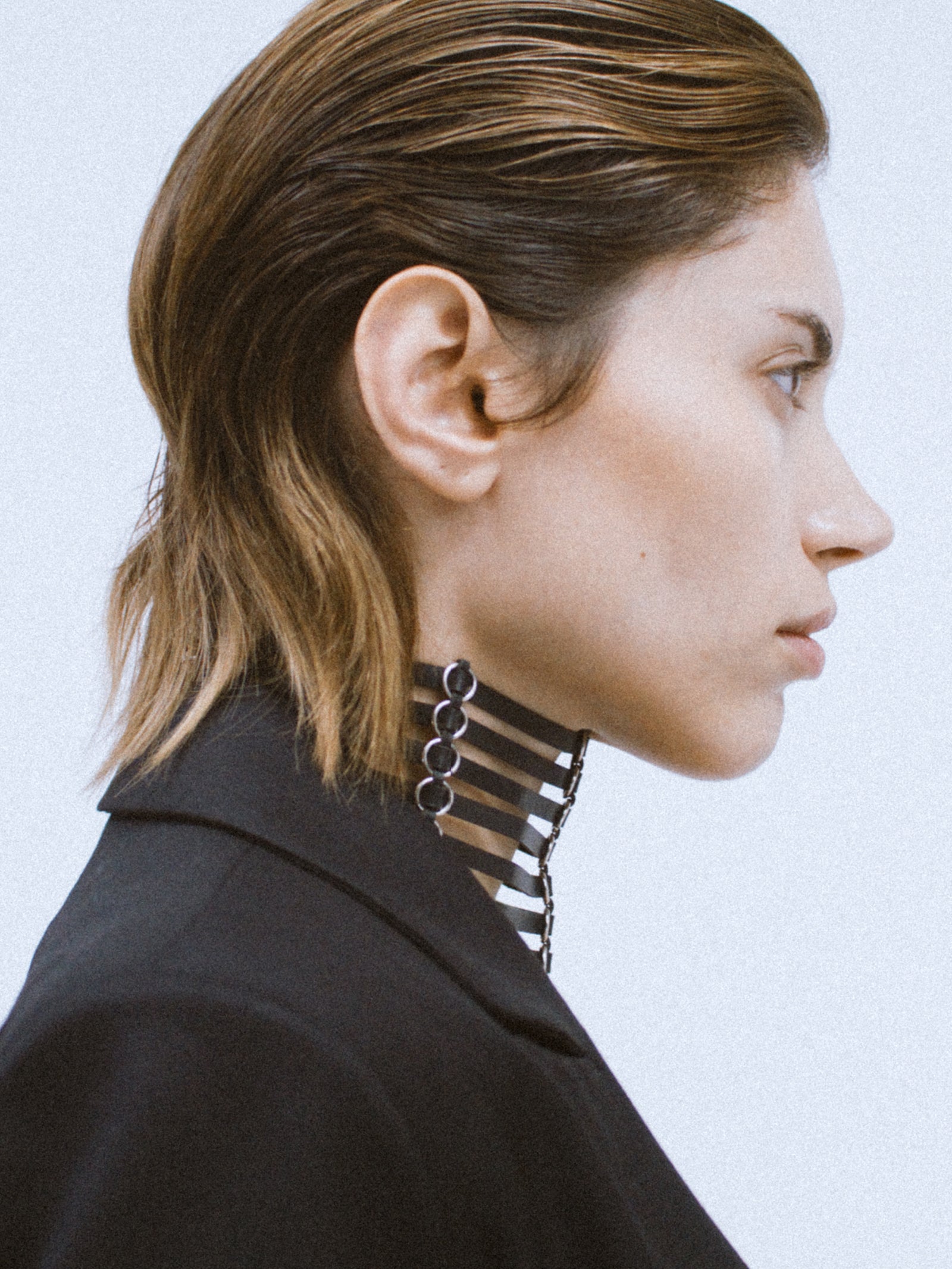 a female model wearing black leather yvy necklace made with thin leather straps and silver rings