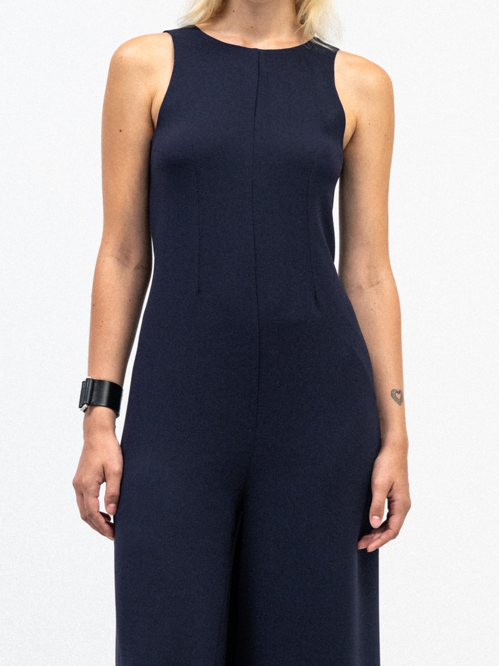 a woman wearing yvy navy blue elegant jumpsuit and black leather yvy eileen bracelet with silver detail