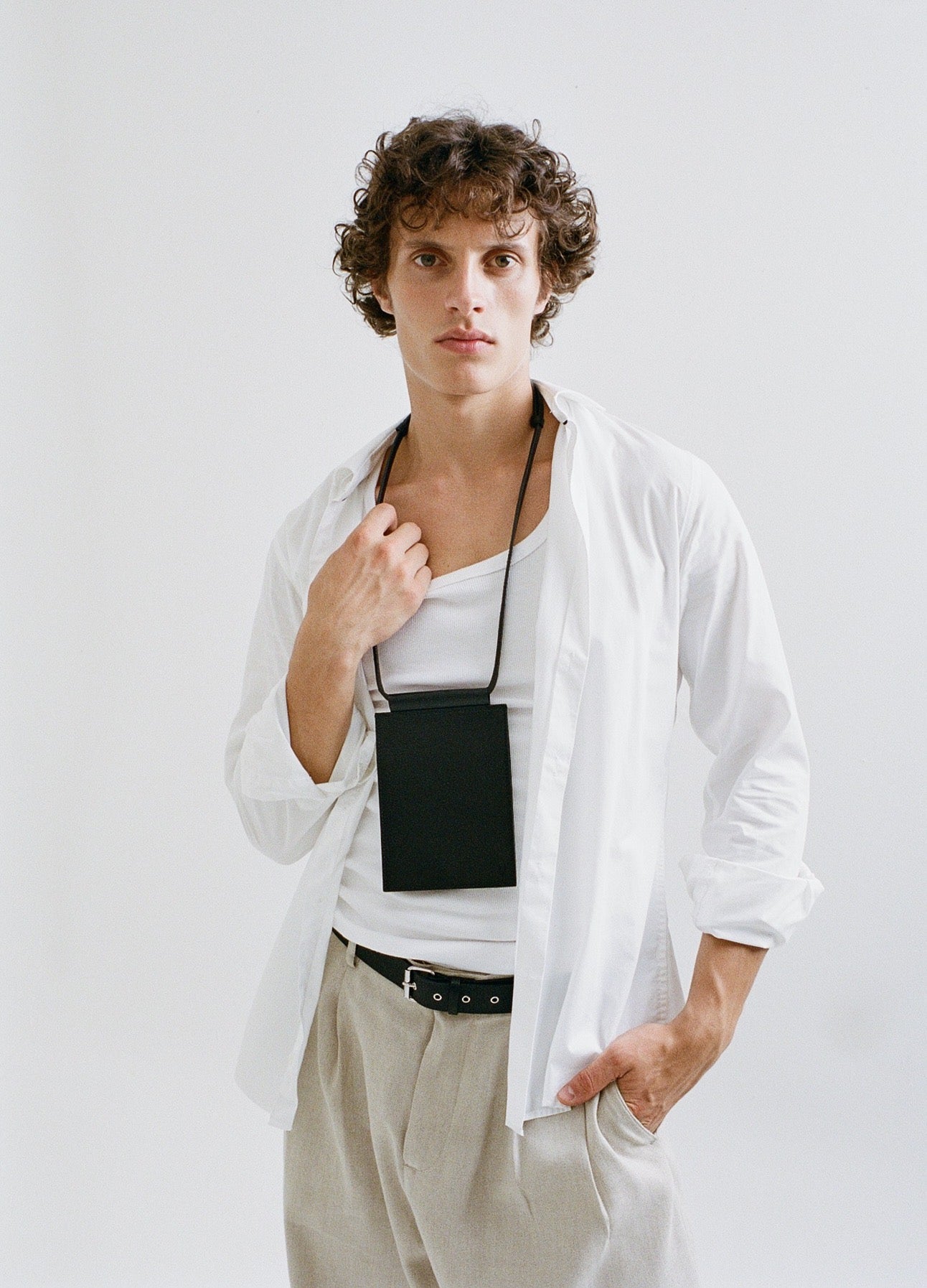 male model wearing yvy travel wallet and thin buckle belt 3