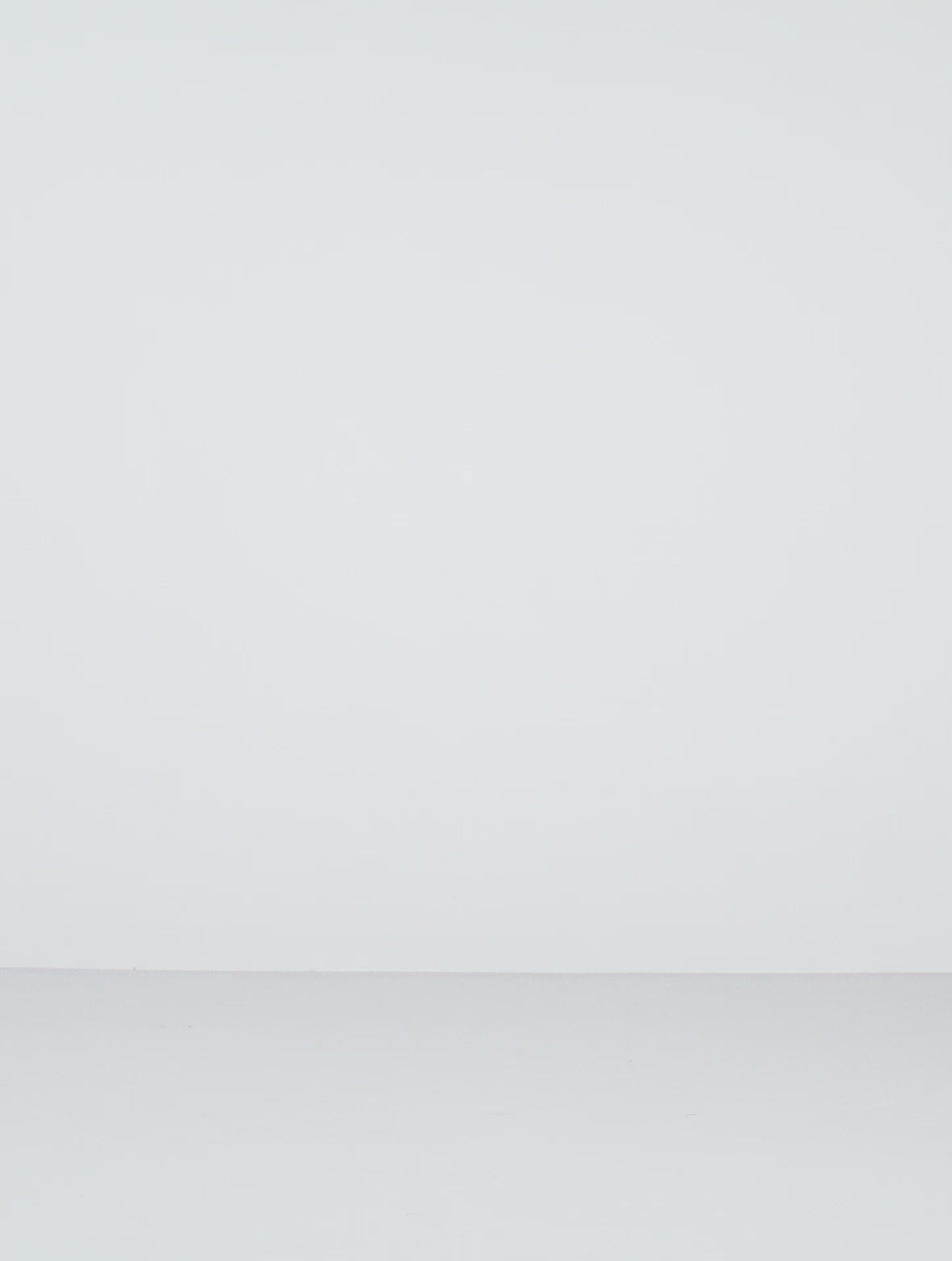 A video of a female model posing in white oversized button-down yvy shirt dress cinched with statement black leather corset belt featuring gold hardware